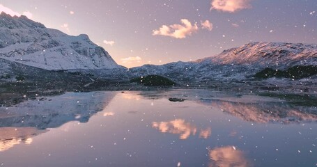 Wall Mural - aerial view from low flying drone of sea coast, fjord, snowy mountains in snowfall at sunset. winter