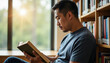 © Alex_Kalin - Quiet contemplation in a sunlit library as a man immerses himself in a book, surrounded by knowledge and serenity