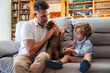 © ADDICTIVE STOCK - Gay couple with their son enjoy a playful moment with pet dog