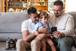 © ADDICTIVE STOCK - Loving gay couple sharing moments on phone with son
