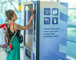 © ADDICTIVE STOCK - Traveler at airport using vending machine for safety supplies