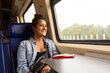 © ADDICTIVE STOCK - Joyful woman on train journey enjoying scenic landscapes