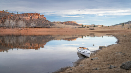 Wall Mural - decked expedition canoe with a wooden paddle on a rocky shore of Horsetooth Reservoir in northern Colorado in cold season scenery