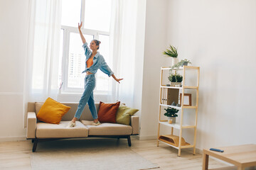 Poster - Joyful Woman Jumping with Music and a Smile in her Home - A Playful Concept of Indoor Relaxation