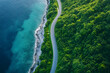 © Ram - Aerial view of winding coastal road surrounded by lush green forest and turquoise blue sea, scenic drive along nature’s edge, serene travel and adventure concept