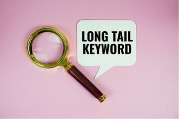 Aufkleber - Long tail keyword text on speech bluble with magnifying glass top view on pink background