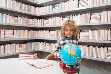 Fototapete - School and students in classroom. Education kids. Child pupil student in the school class. Studying and learning concept. School boy in the library near school supplies. Kid learn geography with globe