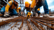 © K.Mongkol - team of engineers working on construction site, focusing on rebar installation. scene captures collaboration and effort involved in building infrastructure