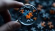 © Wimon - A hand holding a magnifying glass focuses on colorful puzzle pieces scattered on a dark surface.