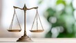 © 1000lnw - A decorative brass balance scale symbolizes justice, fairness, and legal matters, set against a soft-focused background of greenery.