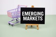 © may1985 - Emerging Markets text message and trolley shopping cart on green background