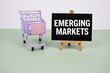 © may1985 - Emerging Markets text message and trolley shopping cart on green background