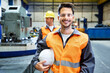 © Westend61 - Portrait of smiling man wearing protective workwear in factory