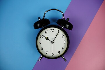 Alarm Clock isolated on blue, purple, pink geometric background