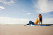 © Westend61 - Netherlands, Zeeland, redheaded woman relaxing on the beach