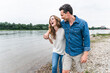 © Westend61 - Happy couple walking at the riverside