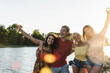 © Westend61 - Group of happy friends having fun in a river at sunset