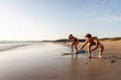 © Westend61 - Young man showing young woman how to surf on the beach