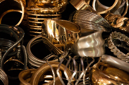 Horizontal close-up shot of a large gold and silver jewelry pile.