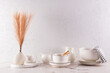 © ADDICTIVE STOCK - Elegant white tableware and decorative vase on marble