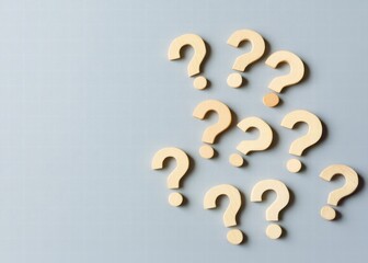 Poster - Wooden question marks scattered on a gray background, symbolizing curiosity and inquiry in a minimalist style.