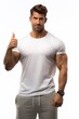 © anatolii - Muscular man in a white shirt shows thumbs up for fitness encouragement and healthy lifestyle