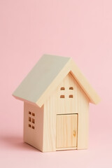 Poster - A model of a house made from wood on a soft pastel colored background conveys property investment and wealth concepts._00002_