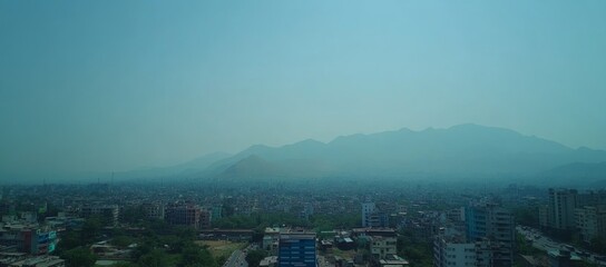 Wall Mural - Hazy city view with mountains background.