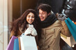 © Prostock-studio - Shopping App. Couple Using Smartphone Holding Shopper Bags Searching New Year Winter Sales Walking Outdoor On A Street At Night