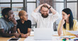 © BullRun - Group of confused multiethnic coworkers using laptop at office
