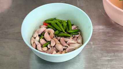 Poster - Chili and garlic in blue bowls on a dining table.