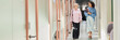 © Seventyfour - Website header shot of mature woman walking along office building hallway with female colleague while discussing work project in modern coworking, copy space