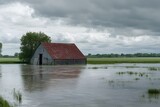 flooded barn in heavy rainfall with stormy sky, rising water, rural landscape, and natural disaster causing dramatic reflections