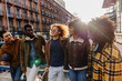 © PintoArt - Happy multi ethnic friends walking and talking in the city