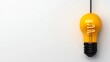 © KN Studio - Illuminating Idea: A single yellow lightbulb hangs from a black cord, casting a warm glow against a minimalist background. This image evokes a sense of inspiration and innovation.