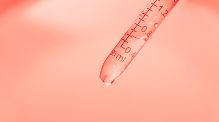 Wall Mural - pink science test tube macro,inclined test tube with transparent liquid and lab dropper inside on pi