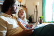 © Marko Geber - Father reading a storybook with his young daughter at home on the couch