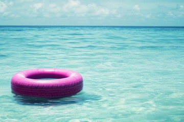 Poster - A pink inflatable ring floats in the calm ocean water, great for use as a background or to represent fun and playfulness
