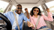 © Prostock-studio - Yes, Summer Vacation Concept. Portrait of excited playful black couple in sunglasses driving car, shaking fists dancing to music enjoying favorite playlist, resting on weekend, windshield view