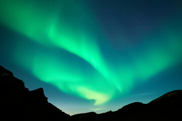 Wall Mural - night starry sky with green aurora borealis northern lights in winter mountains. sky with polar ligh