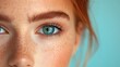 © MUMTAZ - Close-up of a freckled woman's eye with blue iris and defined eyebrows.