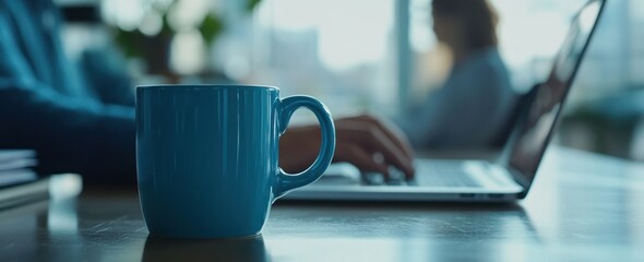 Poster - Blue mug on desk, person using laptop.