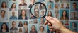 © NoblePix - A hand holding a magnifying glass carefully examines several personal portraits on the wall, representing careful scrutiny or selection. Diversity