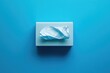 © Web - Stylish Disposable Tissue Container in Soothing Blue Hue Against a Matching Background