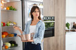 © Pixel-Shot - Displeased young woman with cooking pot near open fridge in kitchen