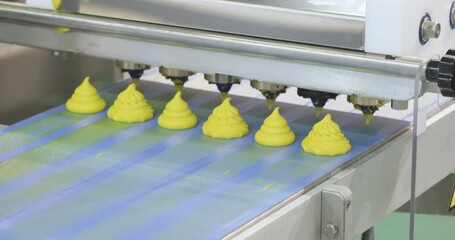 Poster - A conveyor belt with pink frosting on it. The frosting is in the shape of a flower