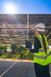 © ultramansk - Engineer in safety vest and helmet pointing towards a solar powered carport, illustrating eco-friendly innovation in parking infrastructure. Solar panels provide shade and sustainable energy.