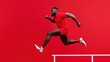 © happysunstock - A man in red athletic wear leaps over a hurdle against a vivid red background, showcasing agility and strength.