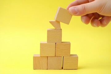 Poster - Hand placing wooden block on pyramid structure.