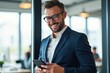© NeedMoreMars - Professional Man in Blue Suit Smiling While Using Smartphone in Modern Office Setting, Perfect for Business and Technology Websites
